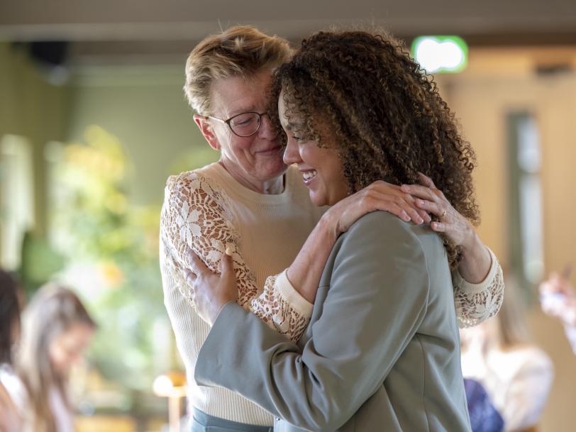 Senior woman smiling and giving a hug to a younger woman