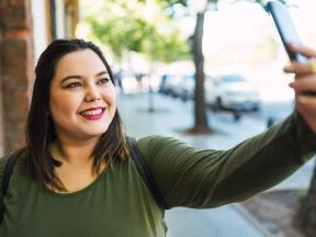 Smiling young woman taking a selfie picture
