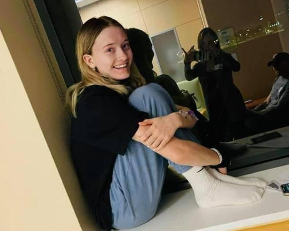 Photo of Ulyssia sitting with her legs folded to her chest